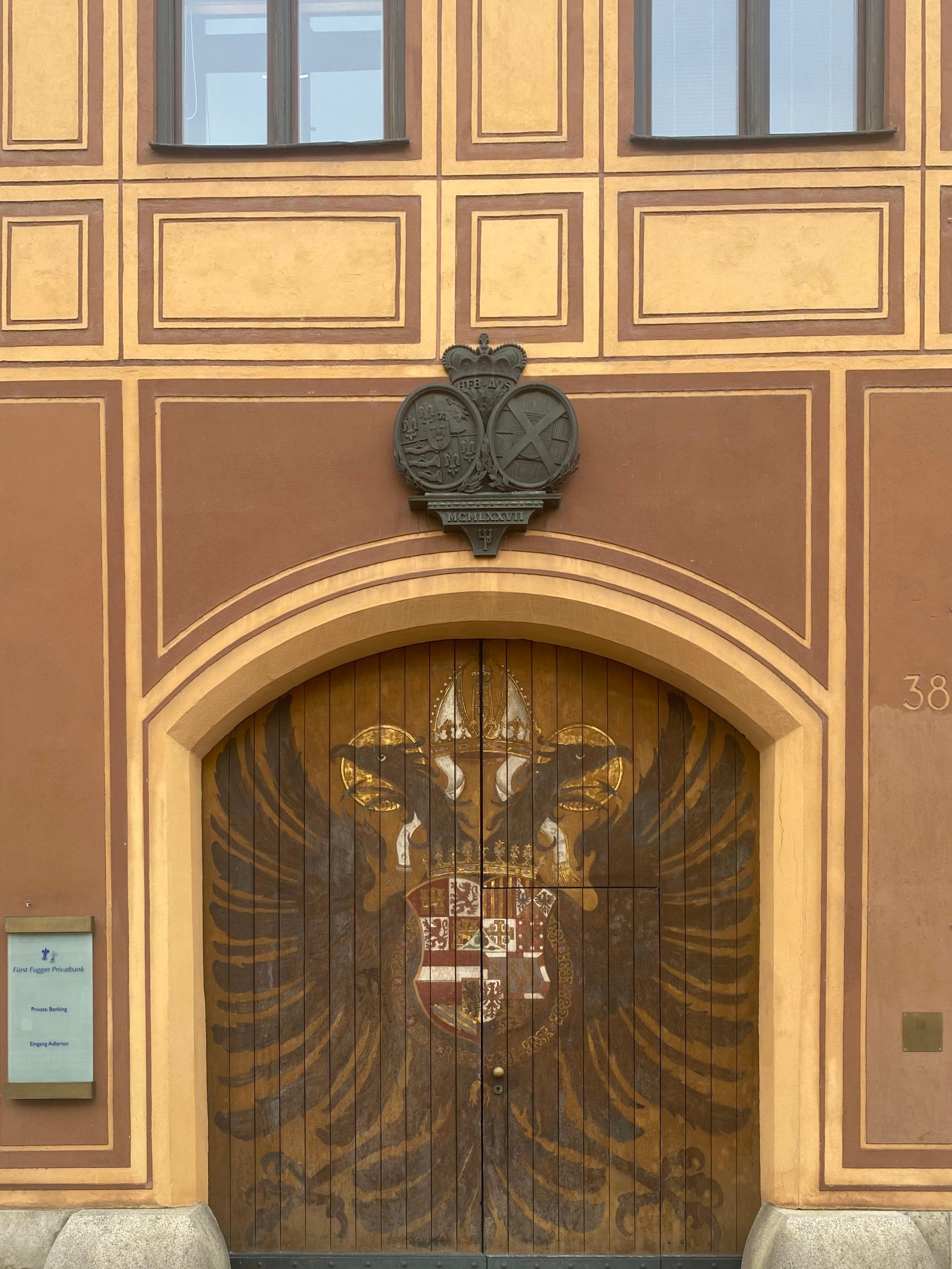 Ornate carved door of the Fuggerhaus with heraldic eagle