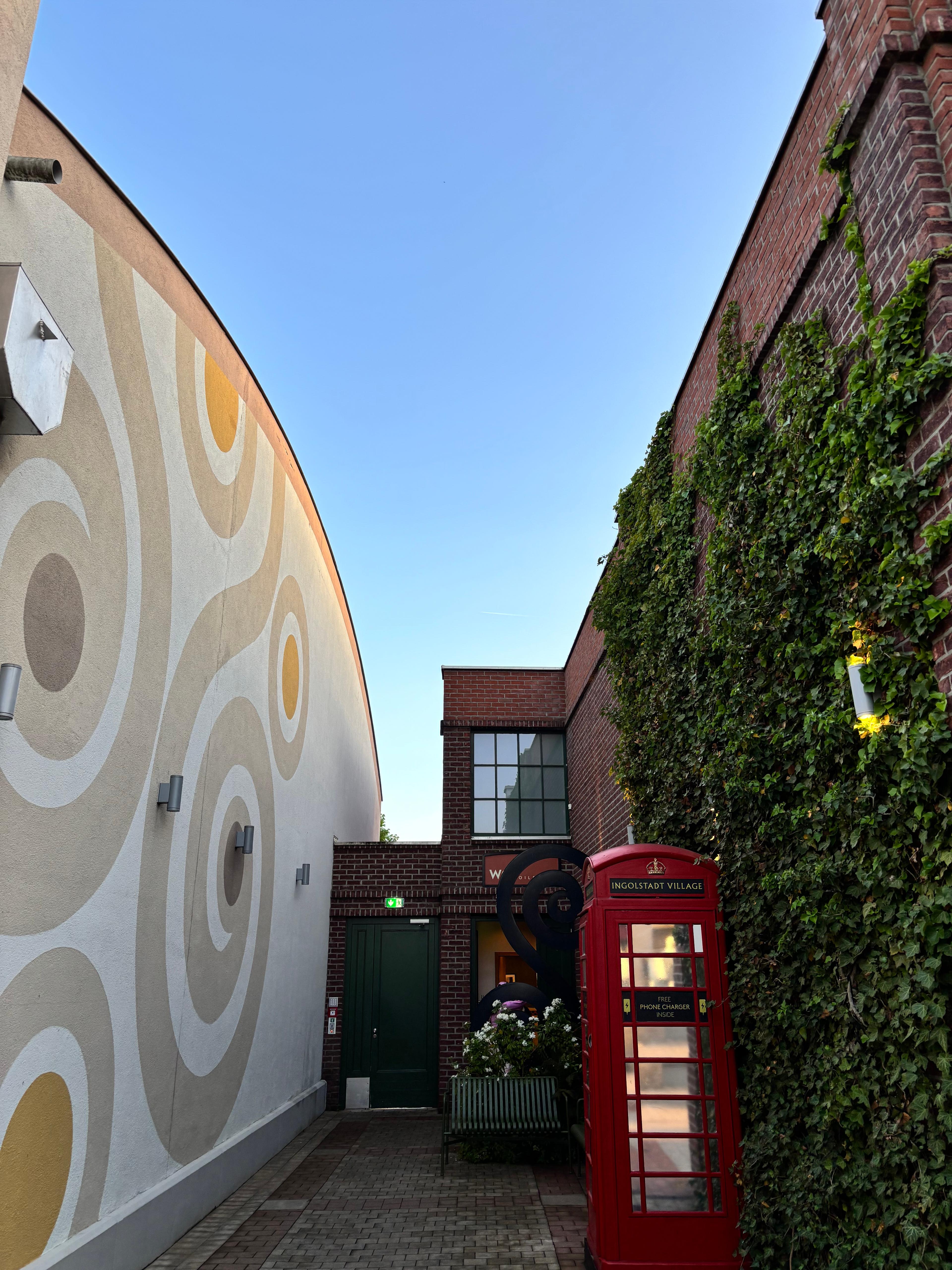 Building with upside-down red phone booth and wavy floor
