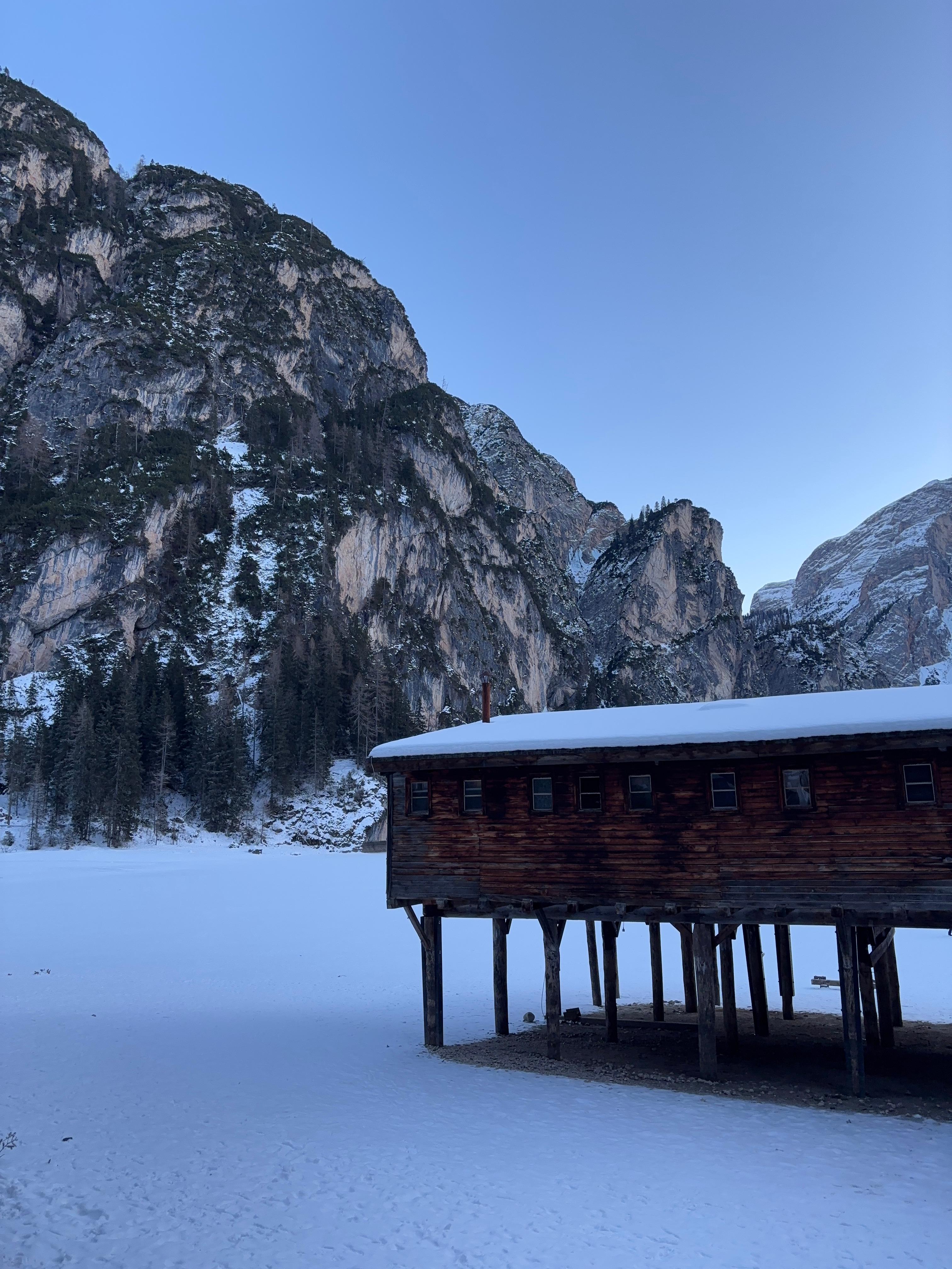 Snow-capped Dolomite peaks with a wooden mountain chalet
