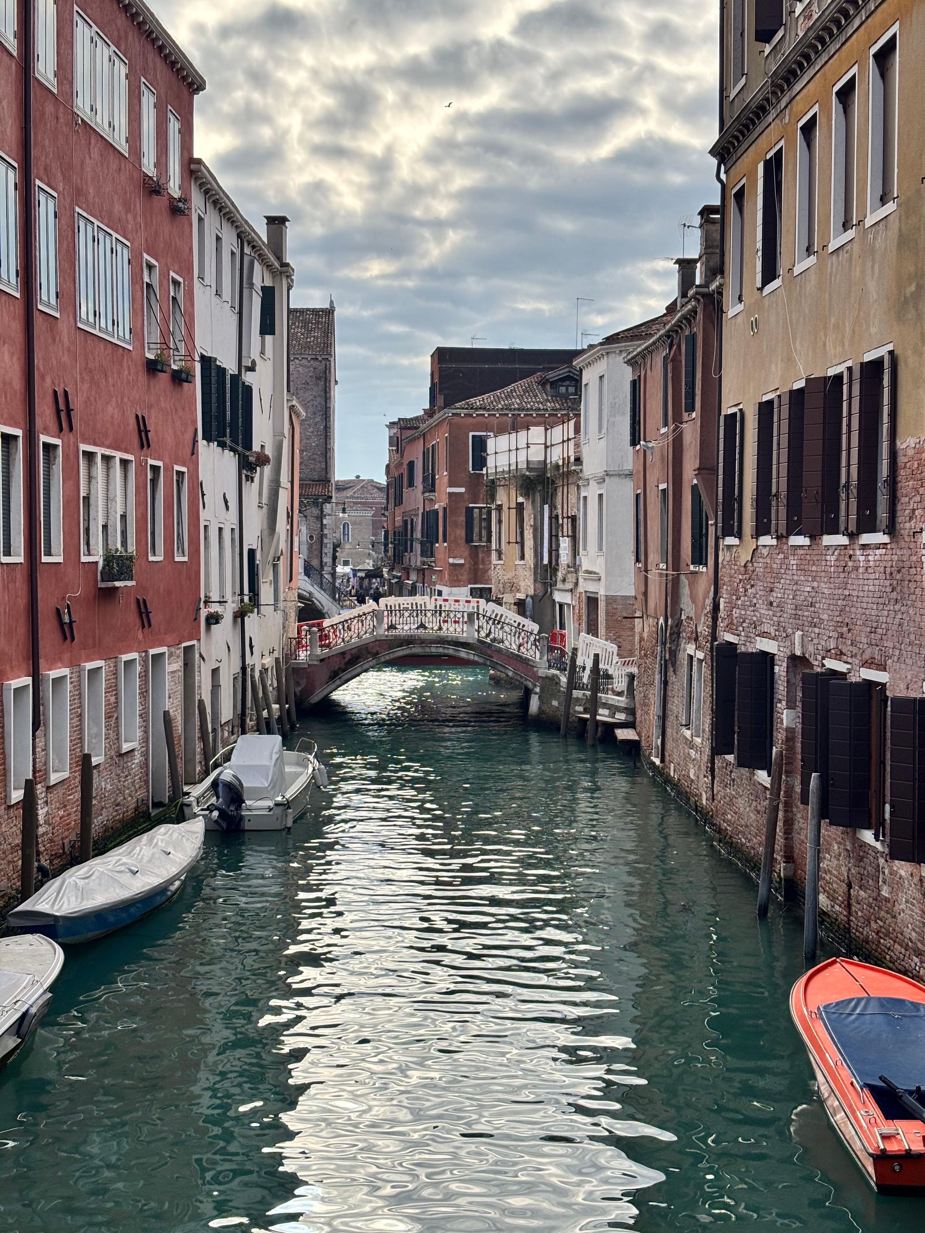 Venice canal with moored boats and brick facades