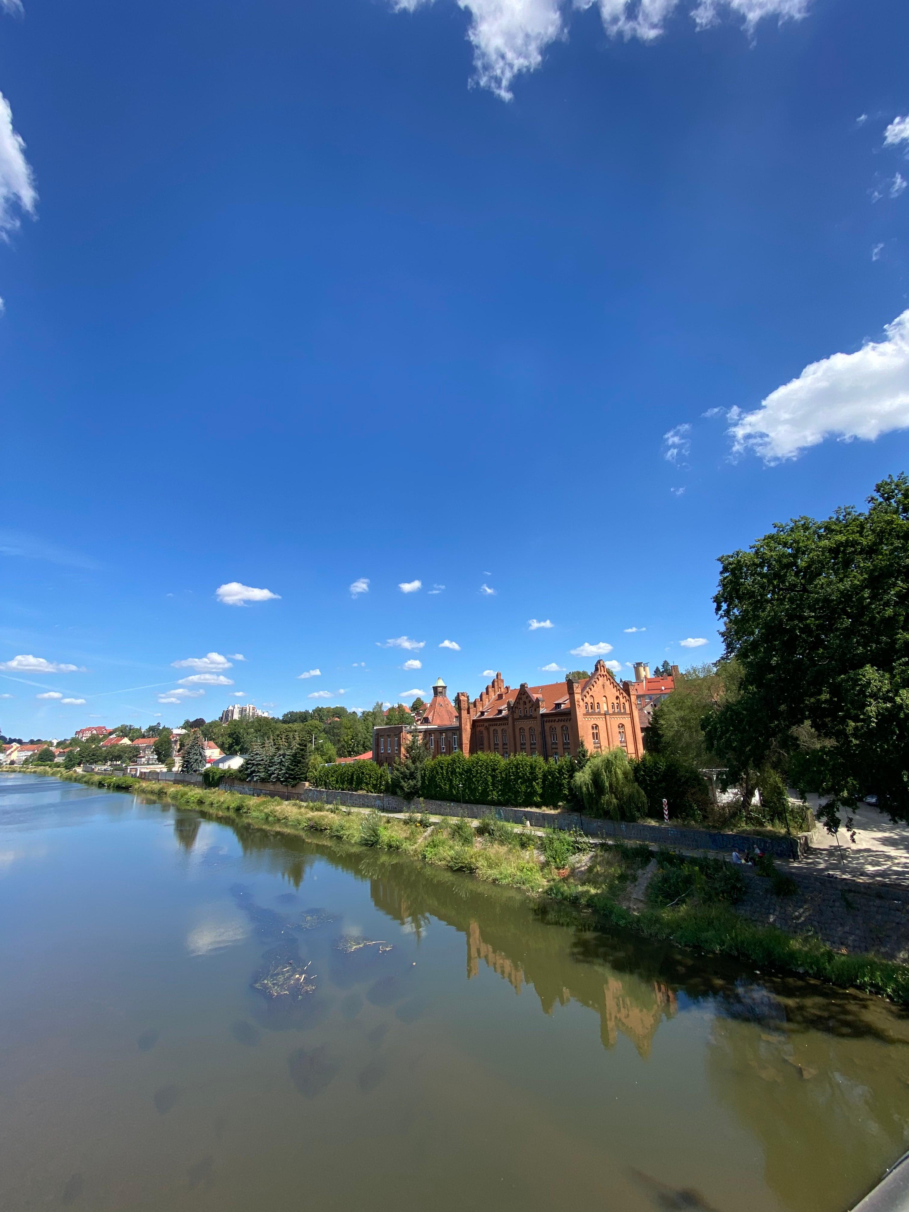 Gothic red brick buildings along a river bank
