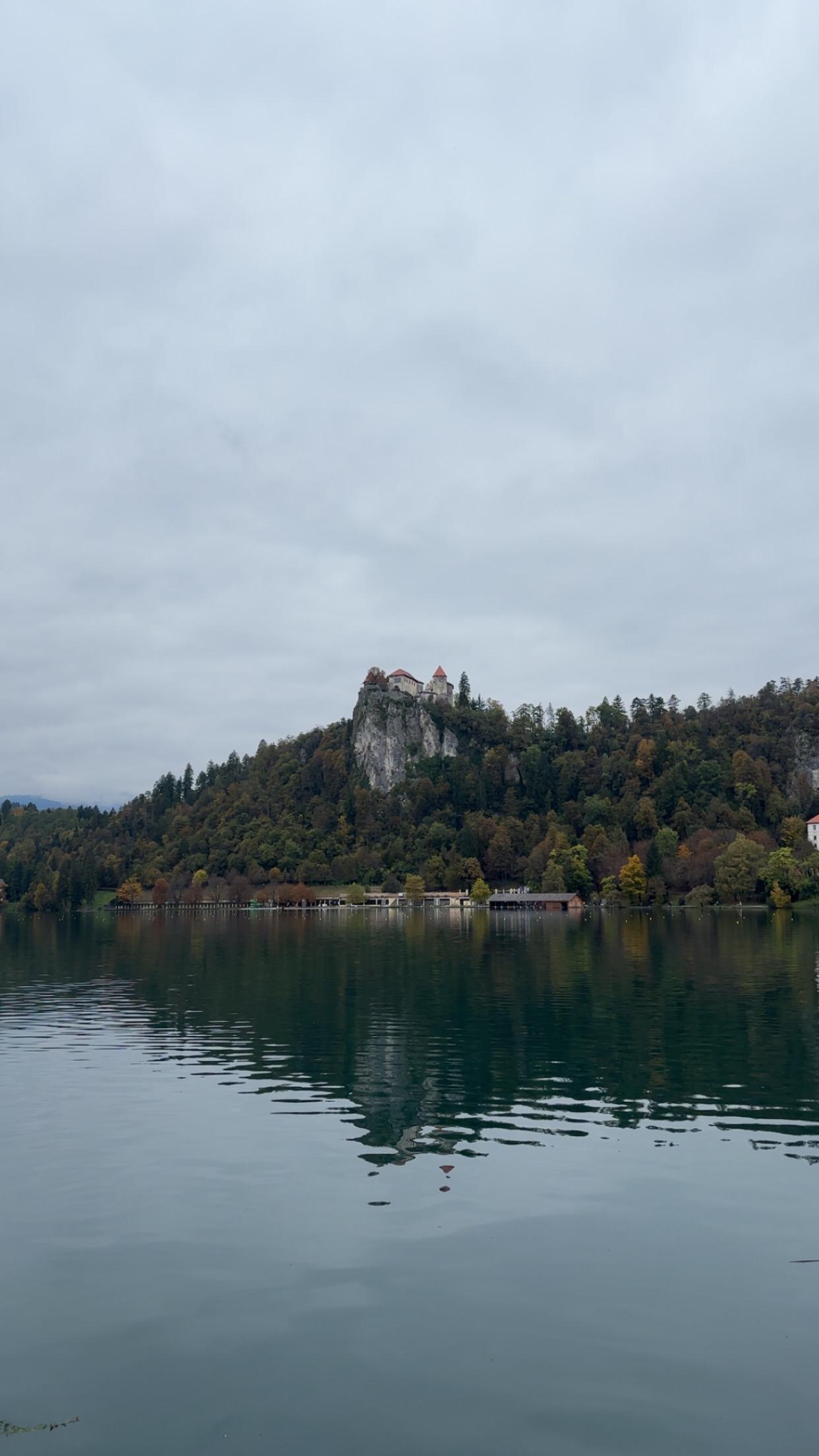 Lake Bled with Bled Castle reflected in still grey water